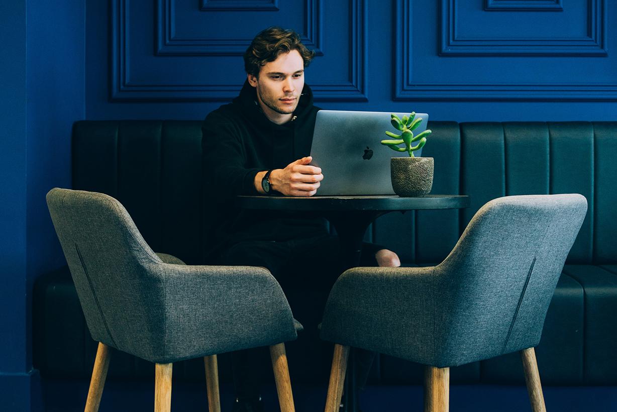 Man sitting at a table using a laptop